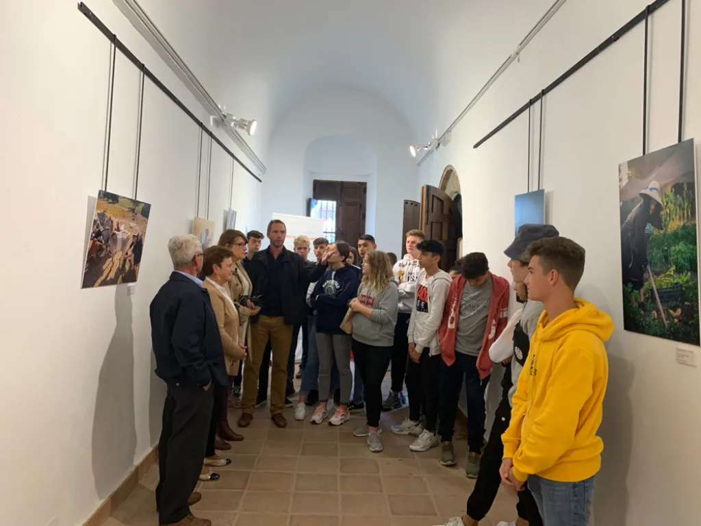 Eine Gruppe geht durch einen Ausstellungsraum mit Bildern an den Wänden.